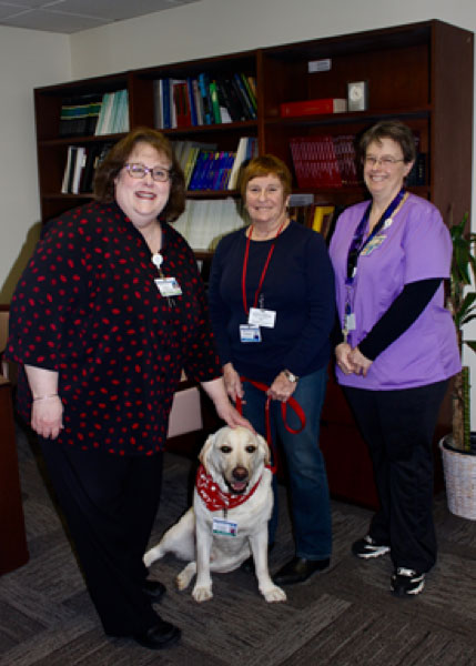 Pictured from left, Donna M. Laudati, Office Manager and Assistant to the Chair of Obstetrics and Gynecology, Murie Nussbaum, Pet Therapy Volunteer, and her dog Will, and Jacqueline Canete, Pet Therapy Coordinator